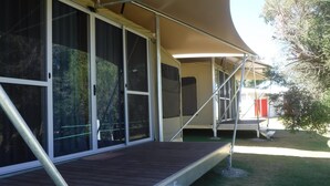 A covered outdoor area with a wooden deck and metal railings. - Tasman Holiday Parks - Ledge Point (Ledge Point)