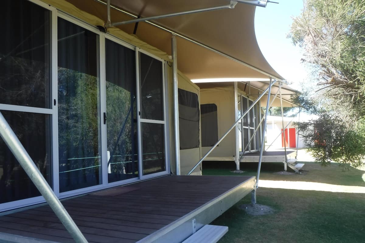 A covered outdoor area with a wooden deck and metal railings.
