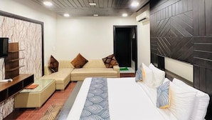 Un dormitorio moderno con cama, sofá y mueble para televisión.