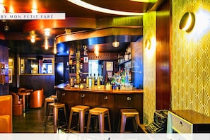 A bar area with stools, a bar counter, and a patterned wall. - The Cosy Cocon -Close to Eiffel- by Mon Petit Faré (Paris)