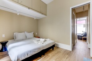 A bedroom with a bed, a bedside table, and a wardrobe. - Retro Color - Near Eiffel Tower- by Mon Petit Faré (Paris)