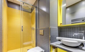 A bathroom with a glass-enclosed shower, a white toilet, and a sink with a mirror above it. - The Sweet Night - Modern&Elegant by Mon Petit Faré (Paris)