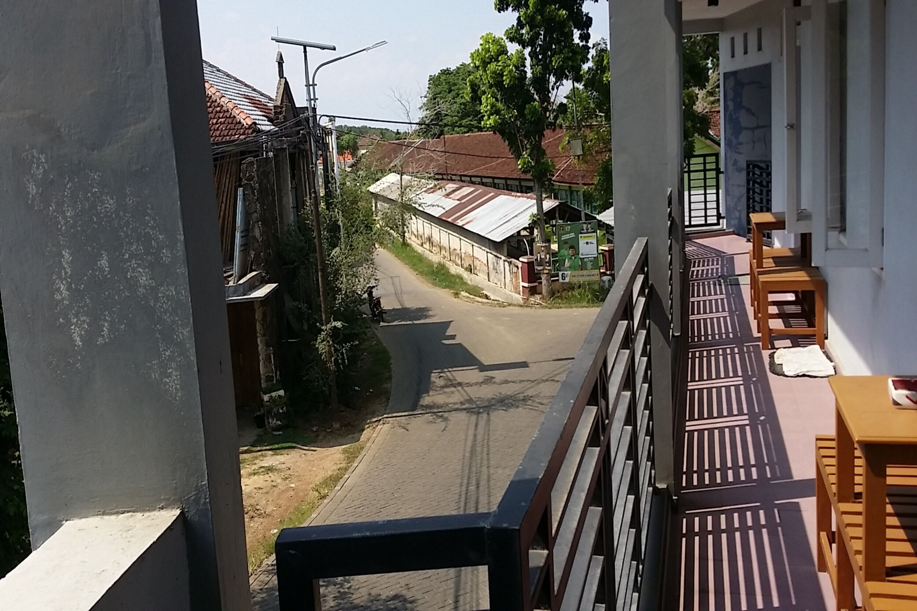 Un balcon donnant sur une rue et des immeubles.