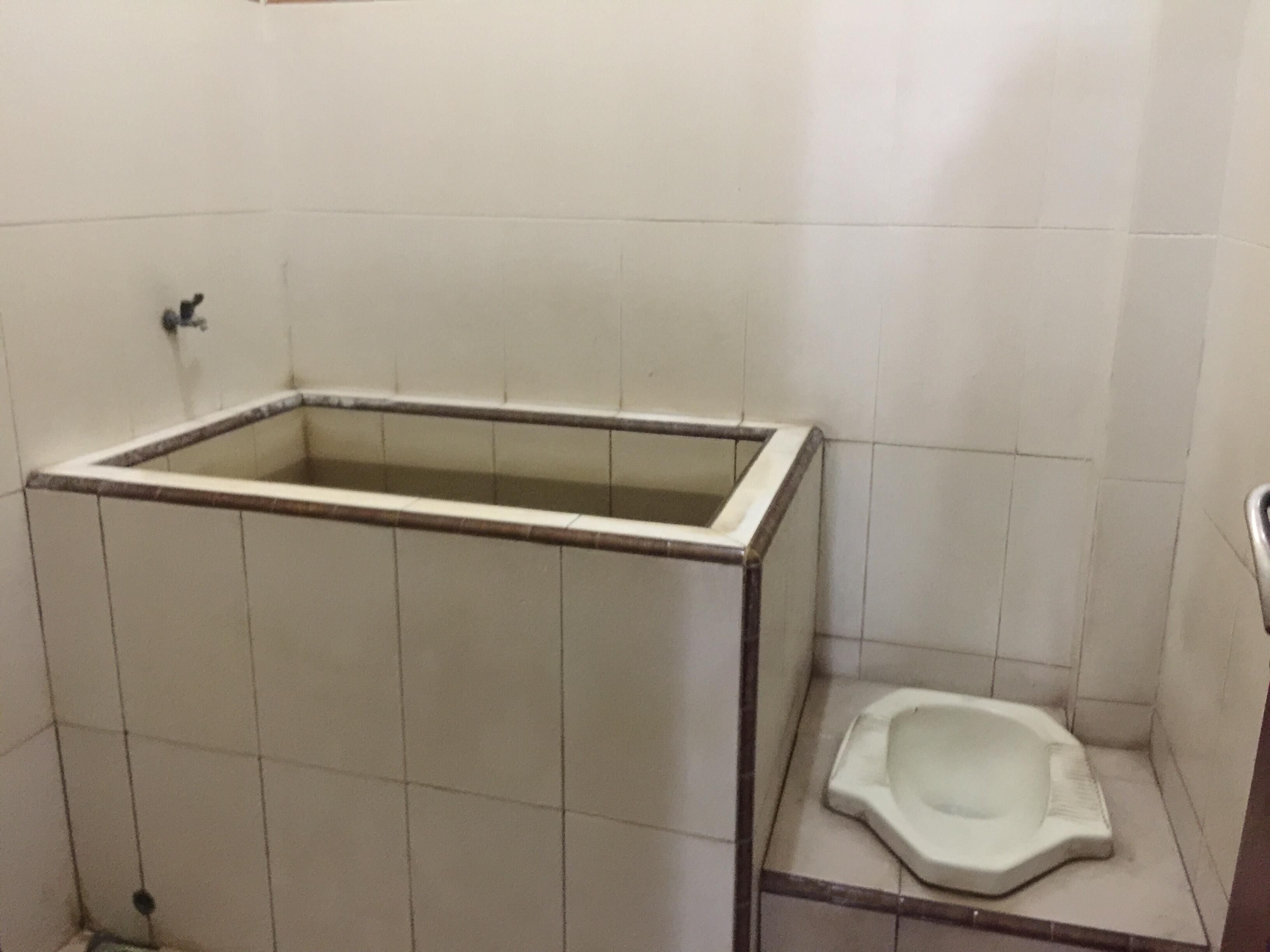 Casa de banho com banheira retangular e sanita de apoio.