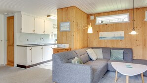 A modern living room with a grey sofa, a white coffee table, and wooden panel walls. - "Sonia" - 3km from the sea by Interhome (Nørre Nebel)