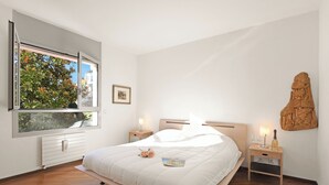 A bedroom with a large window, a bed, bedside tables, a nightstand, and a wall-mounted sculpture. - Sweet Lake View Lugano (Lugano)