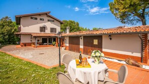A two-story house with a patio, outdoor seating, and a large tree. - Villa Oasi With Private Pool BBQ & Garden Near Sirmione (Sirmione)