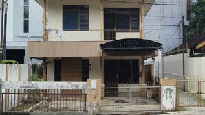 A two-story building with a balcony, a gated entrance, and a small porch area. - Hotel O Penginapan Laras PaminggirNearPesona Alam Seafood Pink Mira (Garut)