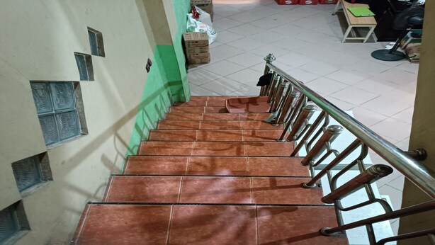 A staircase with brown tiles and a metal handrail. - Hotel O Penginapan Laras PaminggirNearPesona Alam Seafood Pink Mira (Garut)