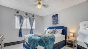 A bedroom with a bed, nightstand, and a mirror. - Appaloosa - Unit A (Colorado Springs)