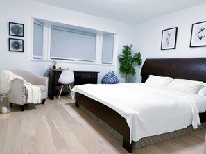 Une chambre à coucher avec un lit, un bureau, une chaise et une fenêtre.