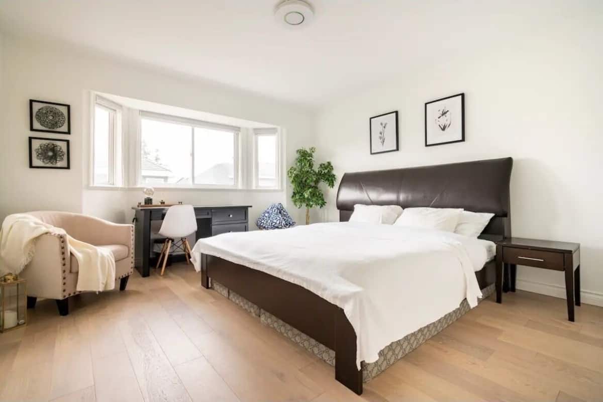 Ein Schlafzimmer mit einem großen Bett, einem Schreibtisch, einem Stuhl und einem Fenster.