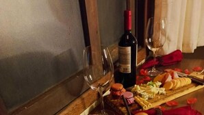 A charcuterie board with various cheeses, meats, and fruits, accompanied by wine glasses and a bottle of wine. - Recanto Zen (Imbituba)
