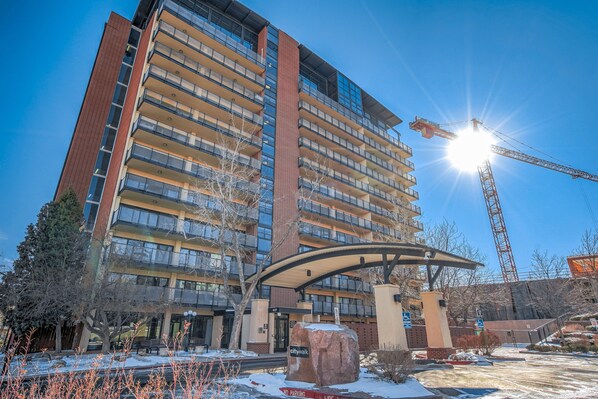 A multi-story hotel with a modern architectural design, featuring a prominent curved entrance and a large rock sculpture in front. - Mid-Nest Unit 708 (Colorado Springs)