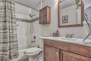 Une salle de bain avec douche, toilettes et lavabo.