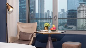 A modern room with a large window, a table with a vase of flowers, a chair, and a lamp. - MaxX by Steigenberger Guangzhou Zhujiang New Town (Guangzhou)
