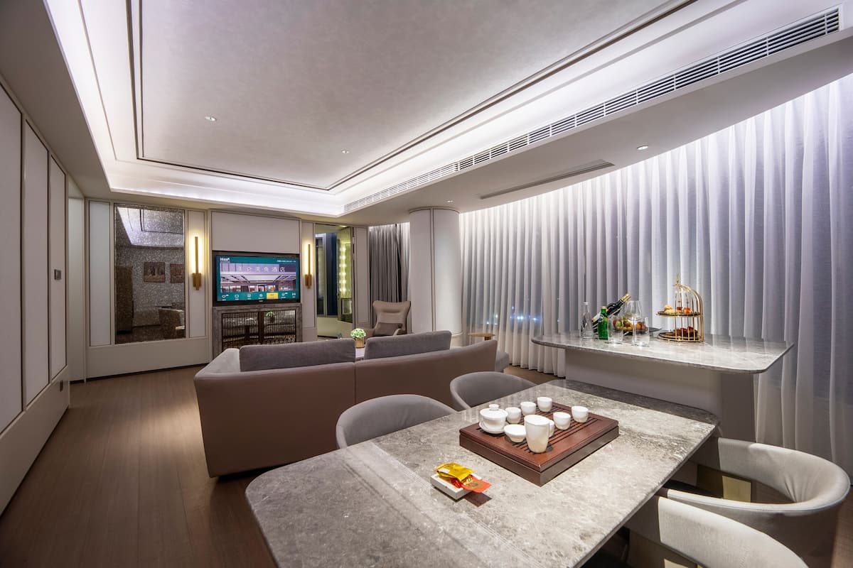 Una sala de estar moderna con sofá, mesa de comedor y televisor.