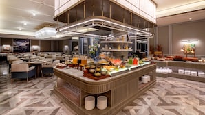 A modern hotel lobby with a buffet area, seating arrangements, and a large chandelier. - MaxX by Steigenberger Guangzhou Zhujiang New Town (Guangzhou)