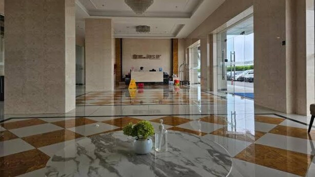 A hotel lobby with a checkered floor, a reception desk, and a large chandelier. - Capital O 93529 September House (Tangerang)