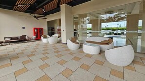 A spacious lobby with a tiled floor, modern seating, and a glass wall offering a view of the outdoors. - Capital O 93529 September House (Tangerang)