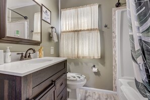 Bañera con ducha, toallas, jabón, shampoo