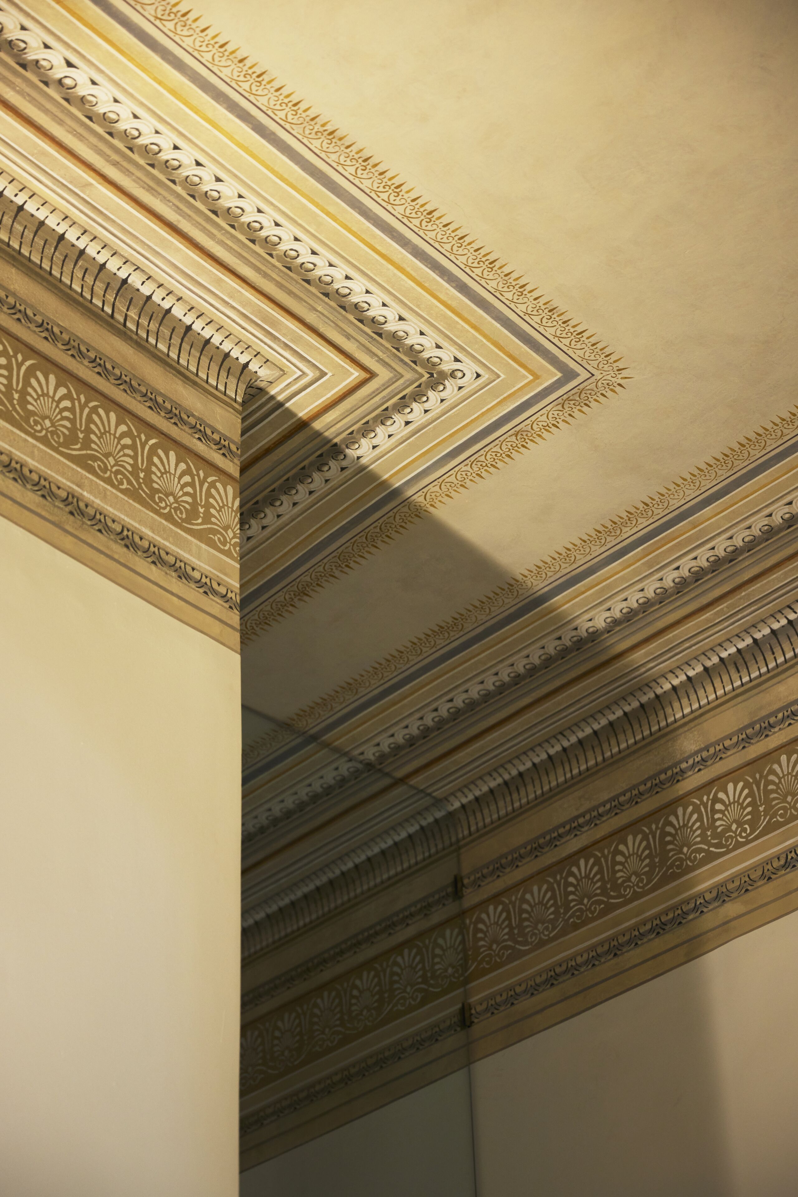 A ceiling with intricate classical architectural moldings.