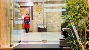 A hotel lobby with a reception desk, a staircase, and a large indoor plant. - Dream Hotel by Bay Luxury (Hanoi)