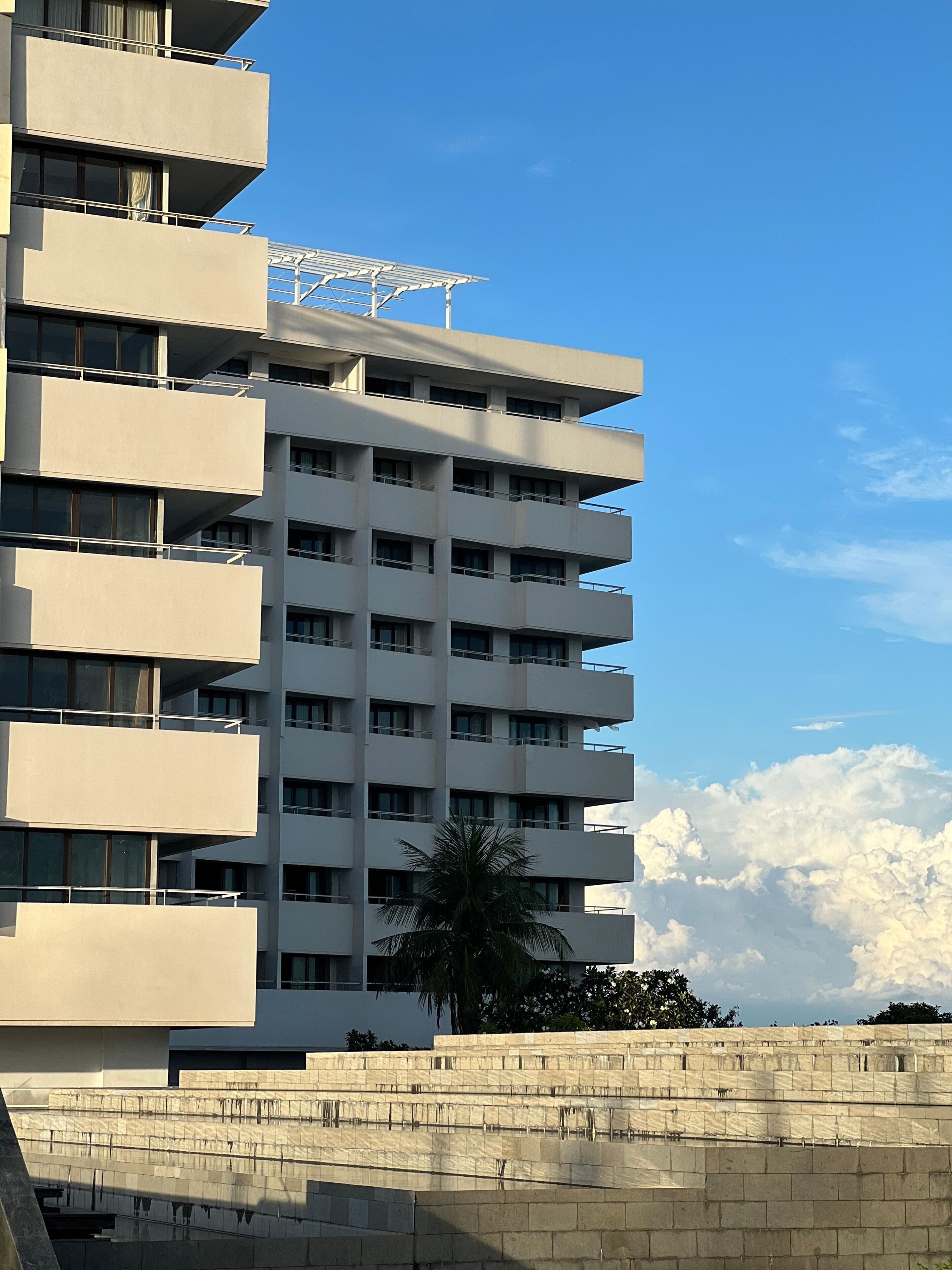 A multi-story building with balconies and a flat roof.