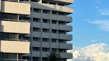 Un edificio de varios pisos con balcones y techo plano.