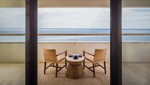 A balcony with a view of the sea, two wicker chairs, and a small round table with a teapot and cups. - Bali Beach Hotel (Denpasar)