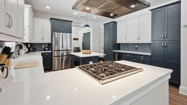 A modern kitchen with stainless steel appliances, a central island, and dark cabinetry. - Luxury Retreat • Hot Tub • Private Fenced Yard (Tampa)