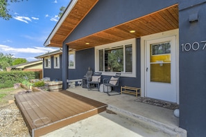 A modern building with a covered porch, outdoor seating, and a statue. - Mid-Evening Star (Colorado Springs)