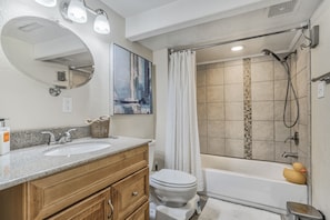 A bathroom with a double sink vanity, a toilet, a bathtub, and a shower. - Mid-Evening Star (Colorado Springs)
