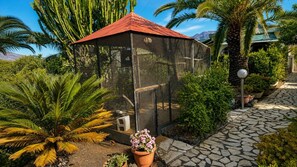 A garden with a gazebo, palm trees, and a stone pathway. - Ferienapartment im Sonnigen Westen von La Palma (El Paso)
