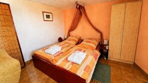 Quarto com cama, guarda-roupa, mesa de cabeceira e um quadro na parede.