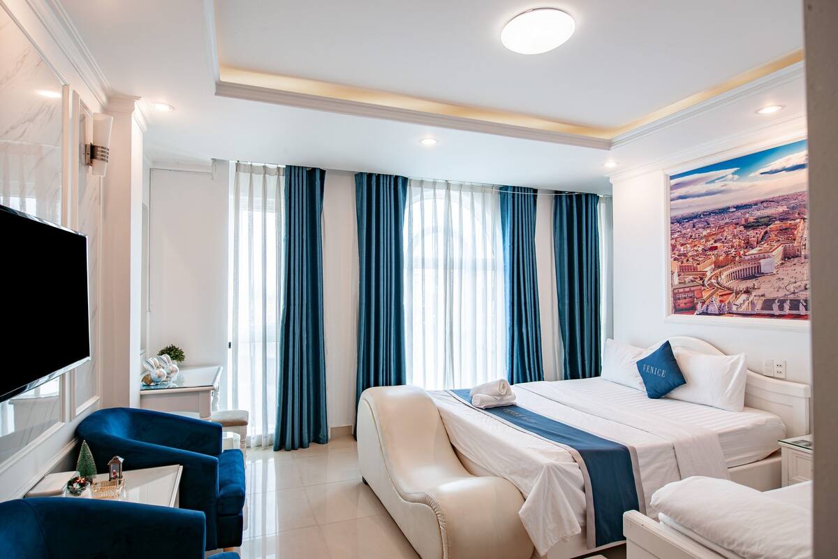 Une chambre d’hôtel avec un lit, une télévision, un bureau et une chaise.