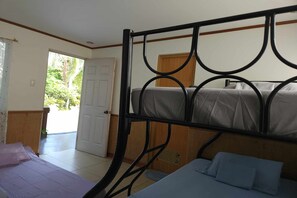 A room with a bunk bed, a single bed, and a door leading outside. - Villa Celine Bay Laguna (Bay)