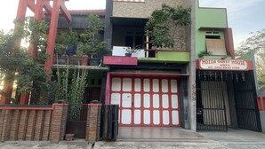 A building with a sign reading "MOZZA GUEST HOUSE ARIA" and a contact number. - Mozza Guest House (Klaten)