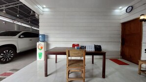 A room with a wooden table, a chair, a water dispenser, and a clock on the wall. - Residence Syariah (Binjai)