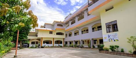 A multi-story building with a courtyard, balconies, and a signboard.