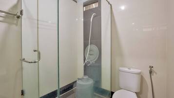 A bathroom with a glass-enclosed shower, a toilet, and a large water dispenser.