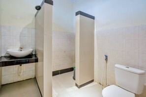 A bathroom with a white sink, a toilet, and a shower area. - Malibou Hotel Medan (Tebing Tinggi)