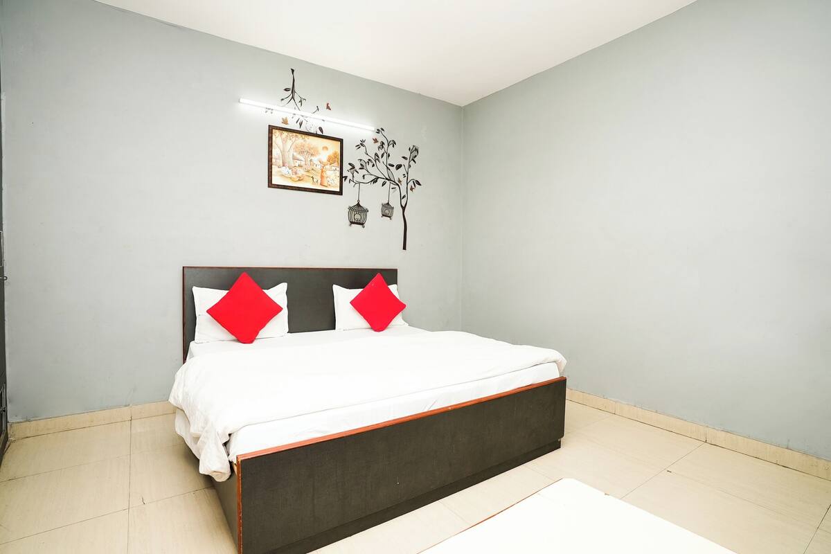 Un dormitorio con una cama, una obra de arte en la pared y un diseño decorativo de árbol.