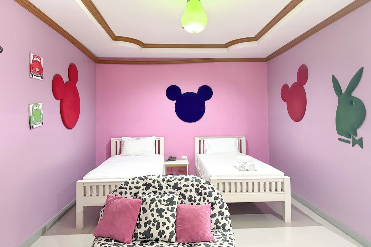 A bedroom with two beds, a sofa, and wall decorations including animal figures.