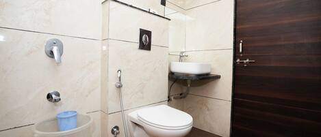 A bathroom with a toilet, sink, and shower.