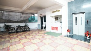A reception area with a checkered floor, a reception desk, and a sign for the office. - The White House (Pune)