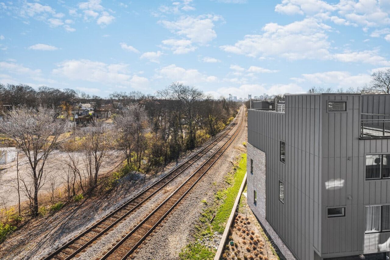 Une voie ferrée avec un bâtiment moderne situé à proximité.