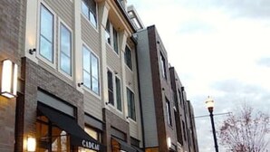 A row of brick buildings with storefronts, including a visible restaurant named "Café."