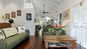 A spacious living room with a high ceiling, a dining area, and a kitchen visible through an open door. - A Tropical Treat @ Sea Level / Port Douglas (PORT DOUGLAS)
