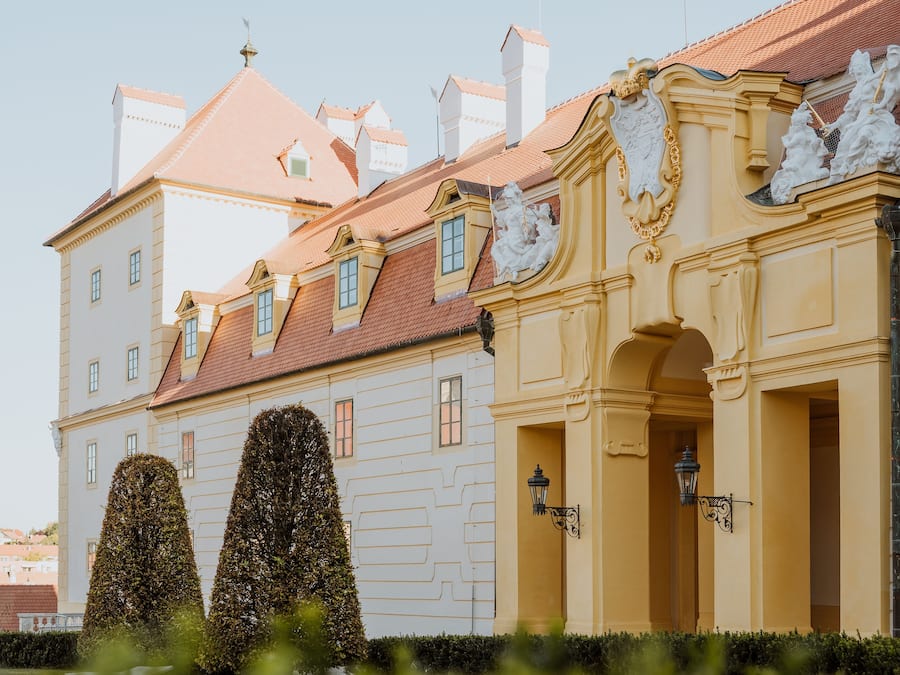 A historic building with a red-tiled roof, ornate architectural details, and a symmetrical facade.